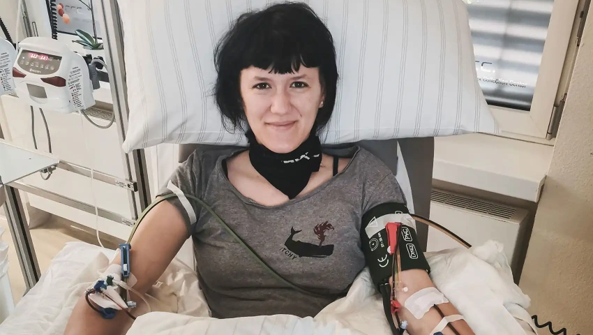 Stammzellspenderin Pauline bei der peripheren Stammzellspende. Sie freut sich, da sie weiß, dass sie ihrem genetischer Zwilling eine Chance auf Heilung schenkt.