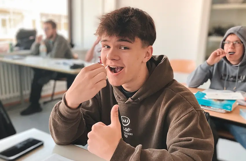 Ein Schüler des OSZ Kfz Berlin nimmt an der VKS-Registrierungsaktion teil und zeigt mit einem Daumen hoch seine positive Einstellung zum Prozess der Stammzellspende