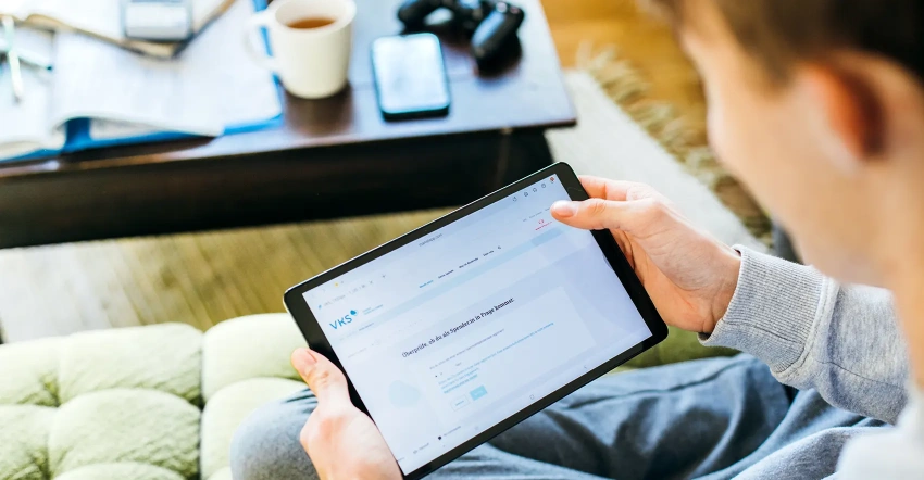 Ein junger potenzieller Stammzellspender schaut auf sein Tablet. Dabei hat er die Webseite vom VKS geöffnet. Er möchte sich als Stammzellspender registrieren und bestellt sich ein Typisierungsset nach Hause.