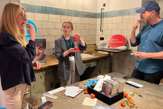 Lebhafte Kommunikation und Informationsaustausch an einem VKS Stand im Survivors Home in Berlin, wo Besucher sich mit einer Registrierung als Stammzellspender:in engagieren können