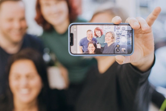 Das VKS Team sitzt glücklich, strahlend zusammen und hält den Moment mit einen Selfie als Erinnerung fest.